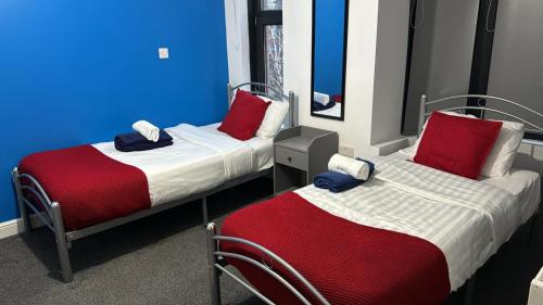 two beds in a room with blue and red at Gregory Boulevard - Stay Sleep Rest in Nottingham