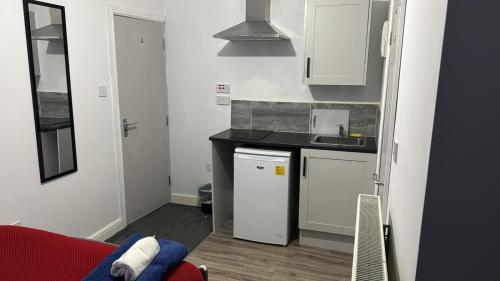 a small kitchen with white cabinets and a sink at Gregory Boulevard - Stay Sleep Rest in Nottingham