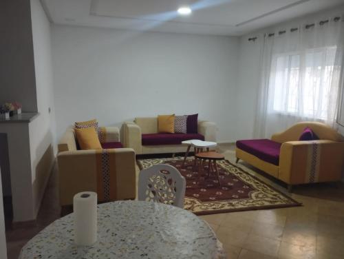 a living room with couches and a table at Appartement Jad in Tunis