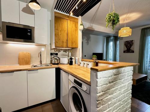 una cocina con lavadora y secadora bajo una barra en Repos entre Paris & Disney, en Nogent-sur-Marne