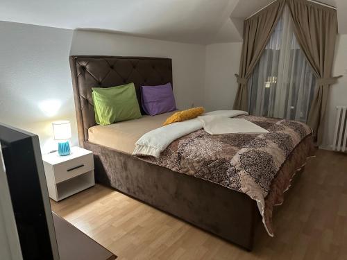 een slaapkamer met een groot bed met kleurrijke kussens bij JS APARTMAN in Nikšić
