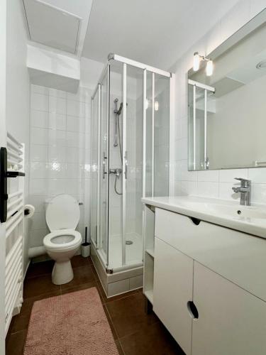 une salle de bain blanche avec toilettes et douche dans l'établissement Repos entre Paris & Disney, à Nogent-sur-Marne