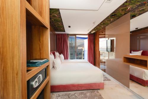 een slaapkamer met een wit bed en een raam bij MAGNIFIQUE HOTEL in Nador