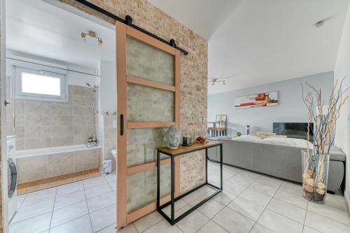 uma casa de banho com um chuveiro e uma porta de vidro em La pause côté jardin em Décines-Charpieu