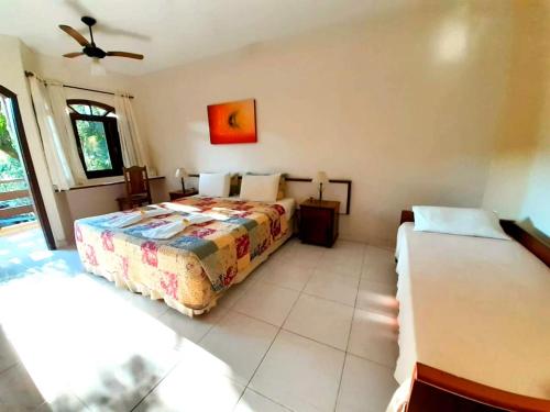 a bedroom with two beds and a ceiling fan at Pousada e SPA Canto do Mar in Guarujá
