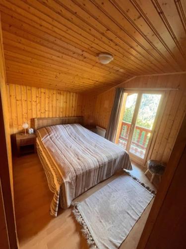 1 dormitorio con 1 cama en una habitación con ventana en Chalet à Mayens-de-Chamoson en Chamoson
