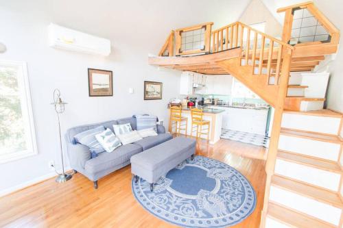 a living room with a couch and a staircase at Milwaukie Riverfront Guest House in Milwaukie