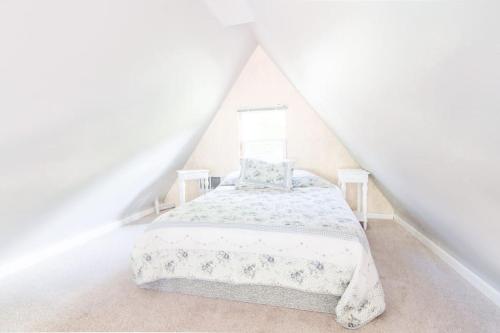 a white bedroom with a bed in a attic at Milwaukie Riverfront Guest House in Milwaukie