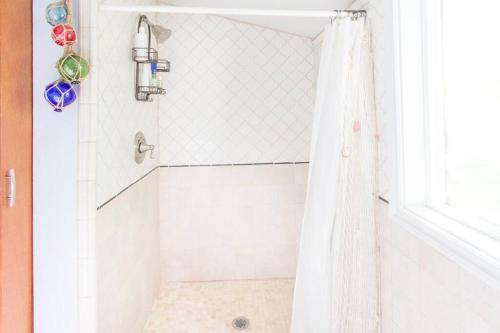 a shower with a white shower curtain in a bathroom at Milwaukie Riverfront Guest House in Milwaukie