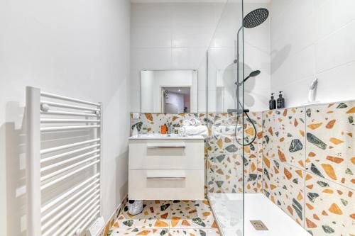 a white bathroom with a shower and a sink at L'escale Balzac in Villeurbanne