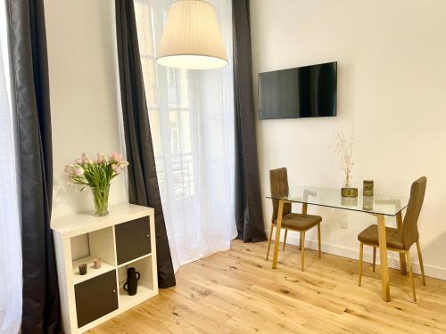 a dining room with a table and a vase of flowers at Confortable central Studio to discover Nice in Nice