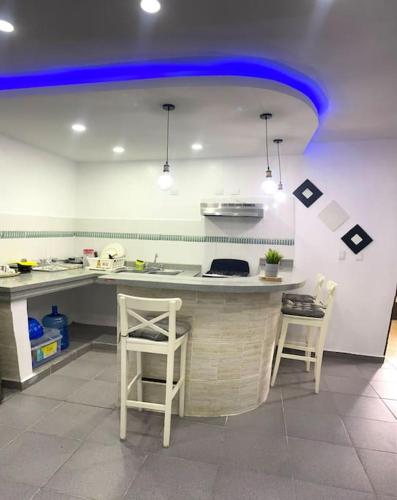 cocina con encimera con 2 sillas y techo azul en The best site for you to rest en Los Mameyes