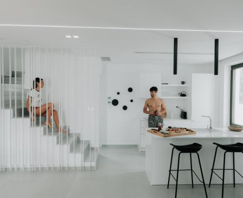 a man and a woman sitting on the stairs in a kitchen at Cocoon Luxury Villas in Hersonissos