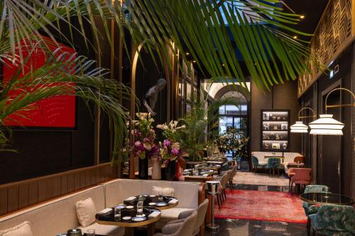 a restaurant with tables and chairs and plants at Umiltà 36 in Rome