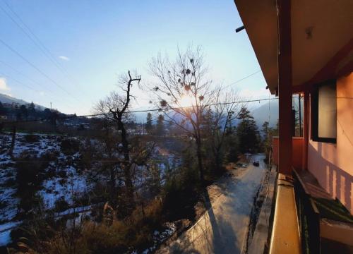 vistas al sol desde el balcón de una casa en Nest Villa Homestay, en Nagar