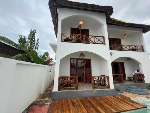 Cette maison est dotée de murs blancs et de parquet. dans l'établissement Villa tangawizi kendwa, à Kendwa