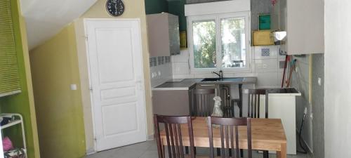a kitchen with a table and chairs in a room at chambre dans maison colocation 20 min de Paris in Antony