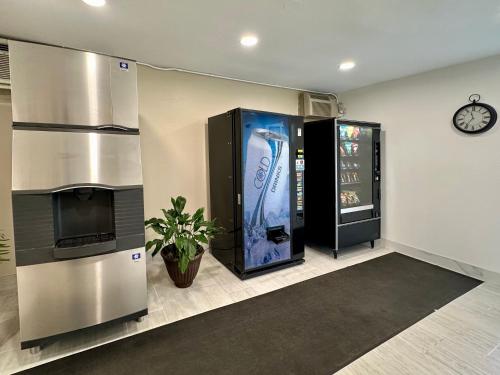 a room with a drink vending machine and a clock at Royal Inn and Suites Charlotte Airport in Charlotte