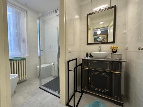 a bathroom with a sink and a mirror and a shower at San Zeno Apartment in Verona