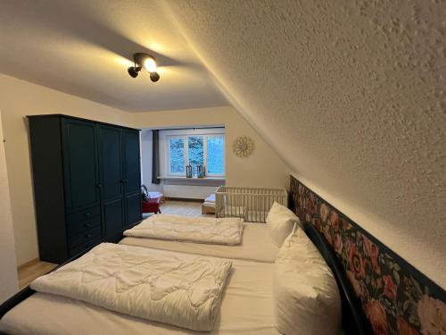 a bedroom with two beds and a staircase at Platell Ferienhäuser Harz Lonau in Herzberg am Harz
