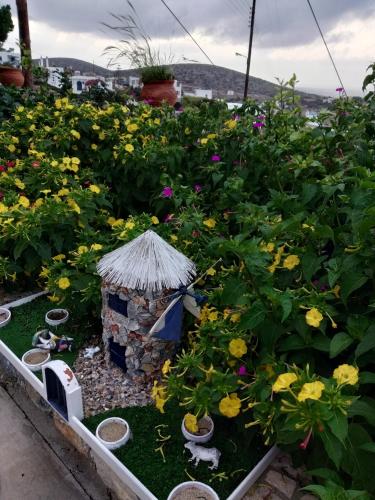 a garden with a small house and flowers at Alexandra’s studios in Iraklia