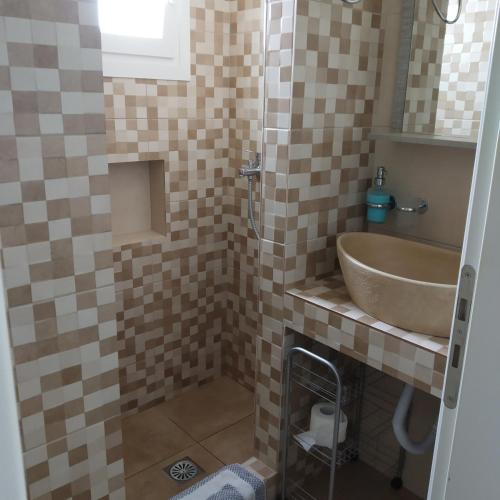 a bathroom with a sink and a shower at Alexandra’s studios in Iraklia