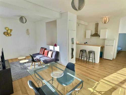 sala de estar con mesa de cristal y sofá en WonderHost, au cœur du quartier du château en Pau