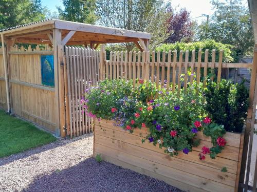 a wooden garden with flowers in a wooden box at Le Paddock Du Val De Lys in Blessy