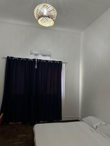ein Schlafzimmer mit einem Bett und einem schwarzen Vorhang in der Unterkunft Pousada de Namacurra 