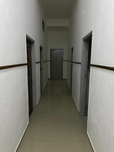 um corredor com portas e bancas num edifício em Pousada de Namacurra 