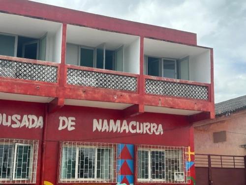 ein rotes Gebäude mit den Worten de nambalamunta darauf in der Unterkunft Pousada de Namacurra 