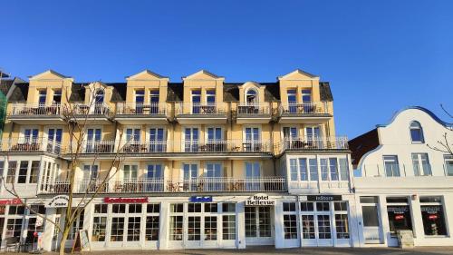 a large yellow building with balconies on top of it at Hotel Bellevue Warnemünde in Warnemünde