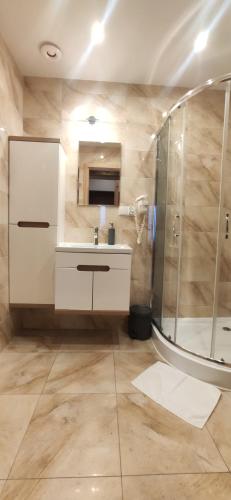 W łazience znajduje się prysznic i umywalka. w obiekcie Prima View w mieście Karpacz