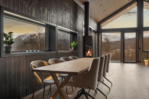 a dining room with a wooden table and chairs at Fantastisk arkitekt tegnet Snøhetta i vakker natur in Sand