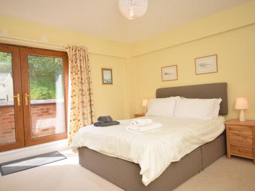 a bedroom with a large bed and a window at 2 Bed in Westward Ho OCE16 in Westward Ho
