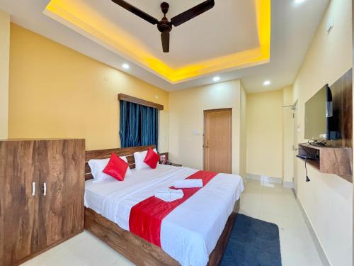 a bedroom with a large bed with red pillows at Hotel Swapna Inn in Puri