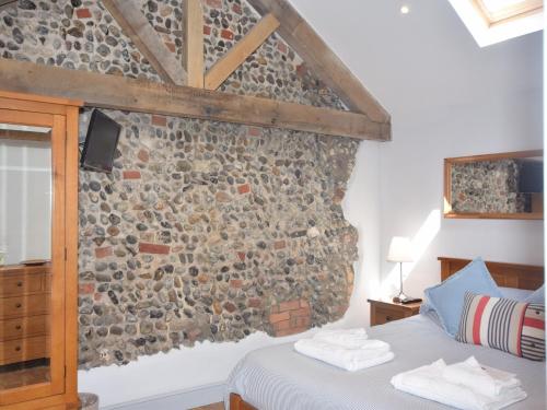um quarto com uma parede de pedra e uma cama em 2 Bed in Winterton on Sea 29236 em Winterton-on-Sea