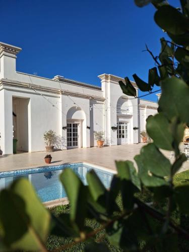 a large white building with a swimming pool in front of it at B&B Le Torri in Santeramo in Colle