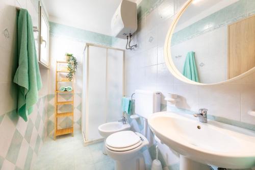 a bathroom with a sink and a toilet and a mirror at Le Perle Marine in Torre Vado