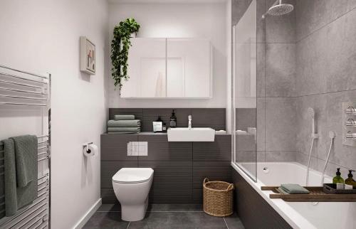 a bathroom with a toilet and a sink and a tub at Luxe Prime 3 Beds Apartment in Central London in London