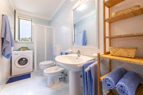 a bathroom with a sink and a washing machine at Le Perle Marine in Torre Vado