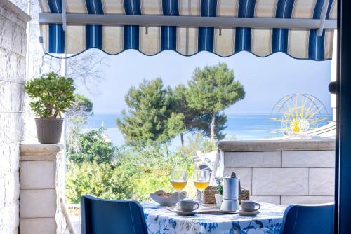 a table with wine glasses and a view of the ocean at Le Perle Marine in Torre Vado