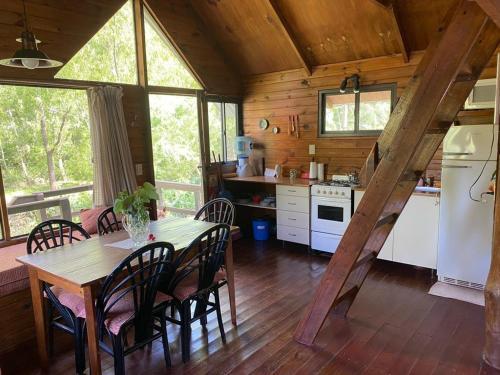 eine Küche und ein Esszimmer mit einem Tisch und Stühlen in der Unterkunft Cabañas El Tercer Ojo Tigre in Tigre