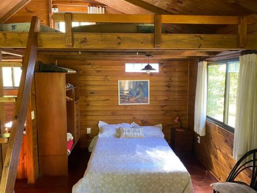 a bedroom with a bed in a wooden cabin at Cabañas El Tercer Ojo Tigre in Tigre