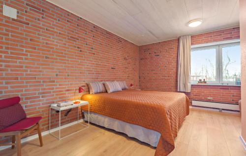 a bedroom with a brick wall and a bed at Nice Home In Bredebro With Wifi in Bredebro