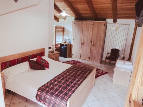 a bedroom with a bed in a room with wooden ceilings at La Majon de Fohten in Montjovet
