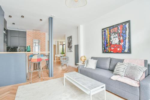 un salon avec un canapé et une cuisine dans l'établissement Duplex à Paris Saint-Ambroise, à Paris