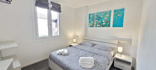 a white bedroom with a bed and two windows at Residence La Corte di San Rocco in Cremeno
