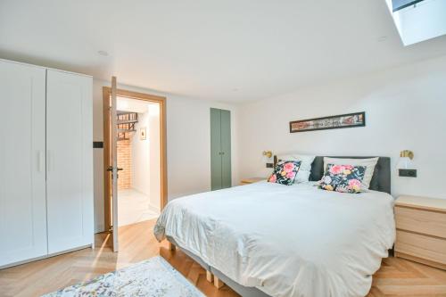 une chambre avec un grand lit blanc avec des oreillers dans l'établissement Duplex à Paris Saint-Ambroise, à Paris