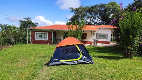 a tent in the grass in front of a house at San Silvestre de Irupana in Chulumani
